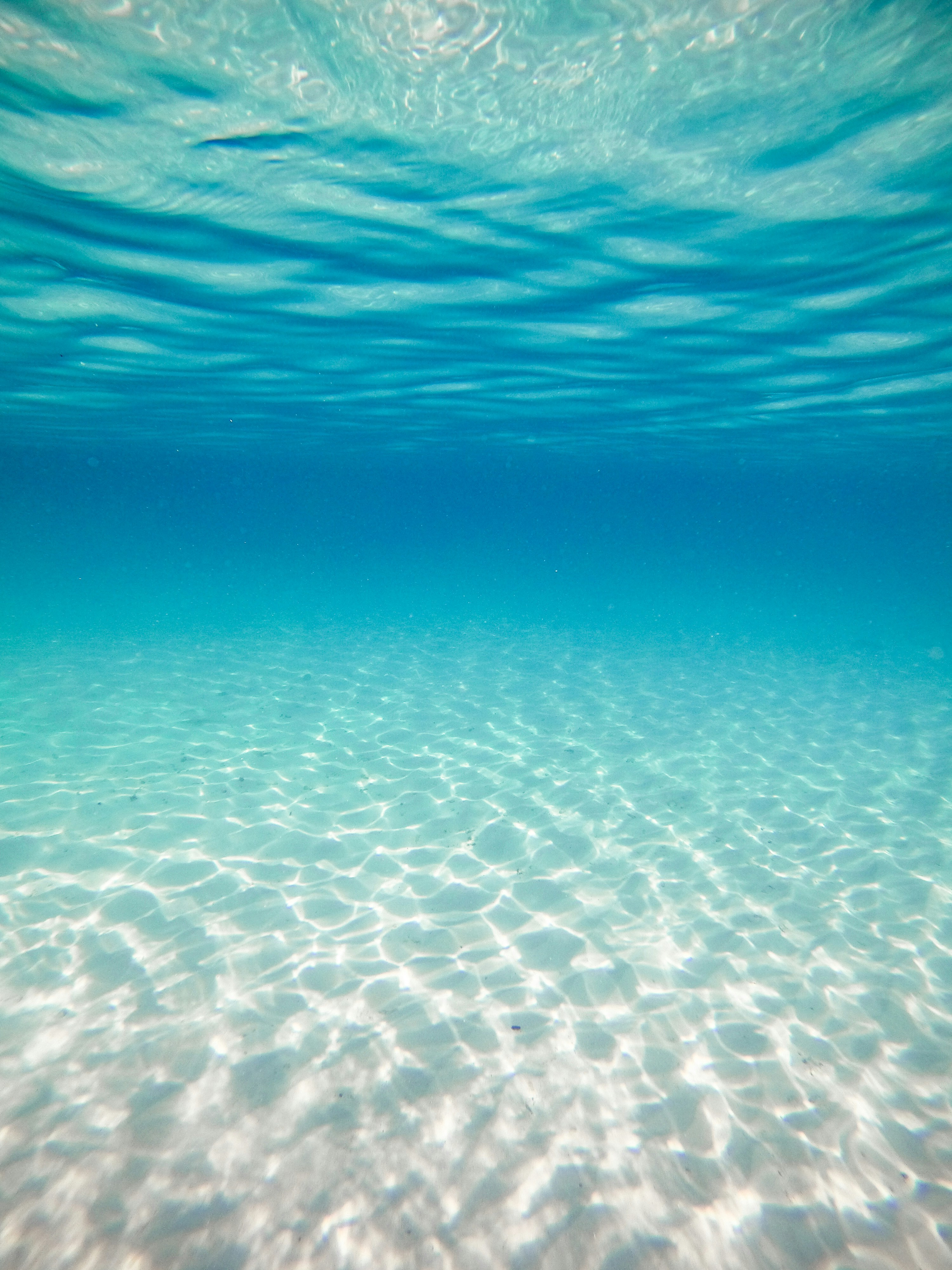 透明感のある明るい青い海と砂地